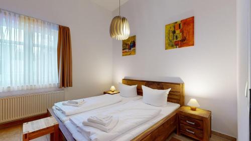 ビンツにあるResidenz Prorer Wiekのベッドルーム1室(白いシーツ付きのベッド1台、窓付)