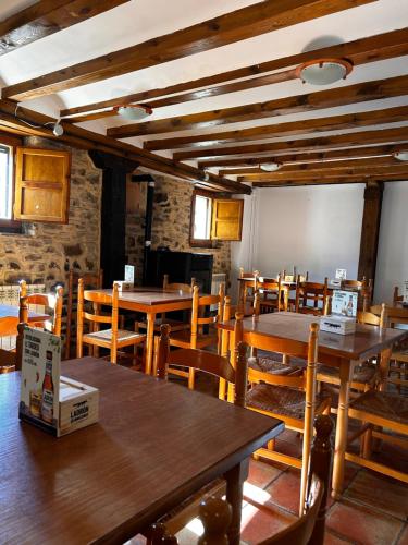 a dining room with wooden tables and wooden chairs at Albergue Rural de Yanguas in Yanguas