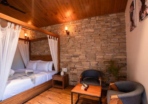 a bedroom with a bed and a brick wall at Moustache Bhimtal Luxuria, Nainital in Bhīm Tāl