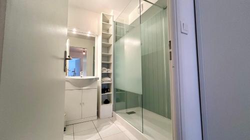 ein Badezimmer mit Dusche und Glastür in der Unterkunft L'échappée in Fort-Mahon-Plage