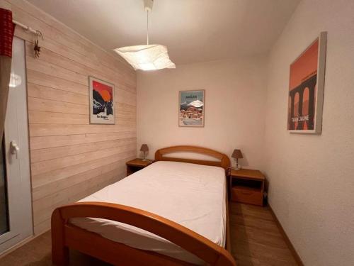 une petite chambre avec un lit et deux tables de nuit dans l'établissement Appartement 2 pièces avec balcon et cuisine équipée aux Angles - FR-1-593-109, aux Angles