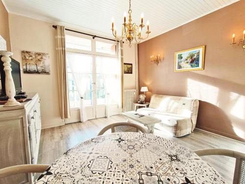 un salon avec une table et un canapé dans l'établissement Le Petit Paradis, T3, wifi, parking, véranda, à Luchon