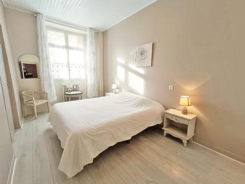 une chambre blanche avec un grand lit et une fenêtre dans l'établissement Le Petit Paradis, T3, wifi, parking, véranda, à Luchon