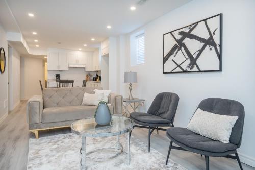 a living room with a couch and two chairs and a table at The Oasis in Bowmanville