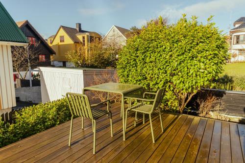 un tavolo e due sedie su una terrazza di legno di Charming Retreat in the Heart of Tórshavn a Tórshavn