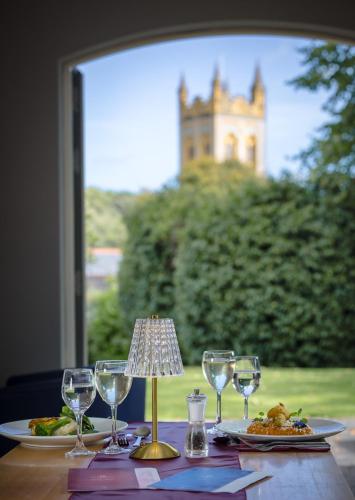 a table with plates of food and wine glasses at Northgate House in Buckfastleigh