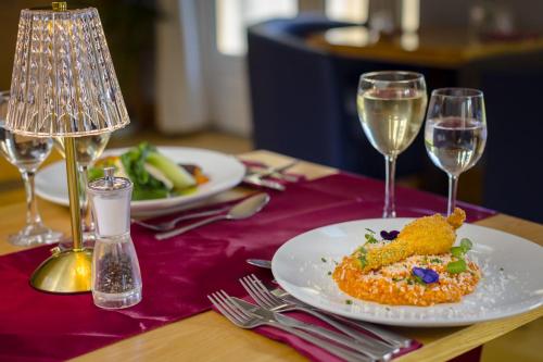 a table with a plate of food and two wine glasses at Northgate House in Buckfastleigh