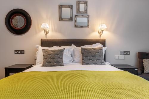 a bedroom with a large bed with a yellow blanket at The Bickley Mill in Newton Abbot