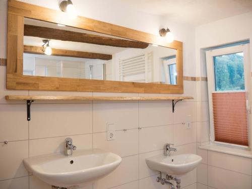 een badkamer met 2 wastafels en een spiegel bij Ferienhof Verse Ferienwohnung Waldblick in Lennestadt