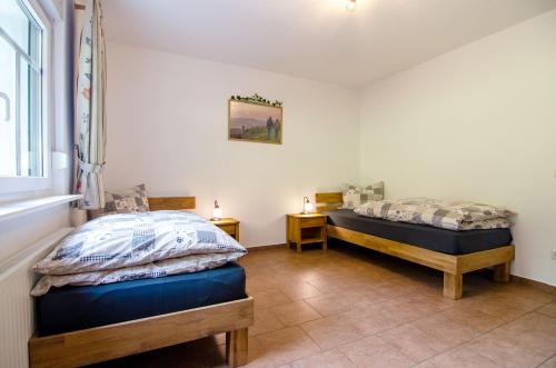 two twin beds in a room with a window at Ferienhof Verse Ferienwohnung Kornkammer in Lennestadt