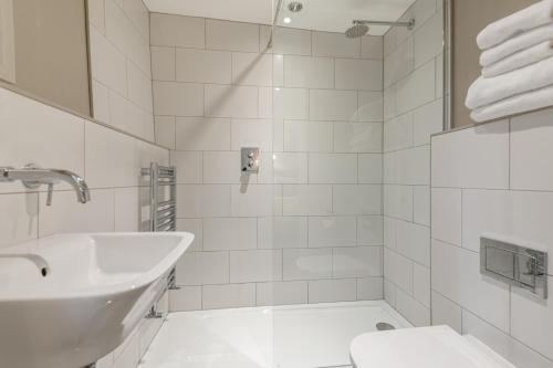 a white bathroom with a sink and a toilet at The Bickley Mill in Newton Abbot