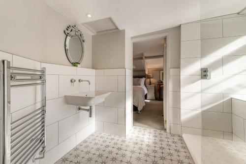 a white bathroom with a sink and a mirror at The Bickley Mill in Newton Abbot