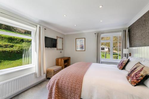 a bedroom with a bed and a large window at The Bickley Mill in Newton Abbot