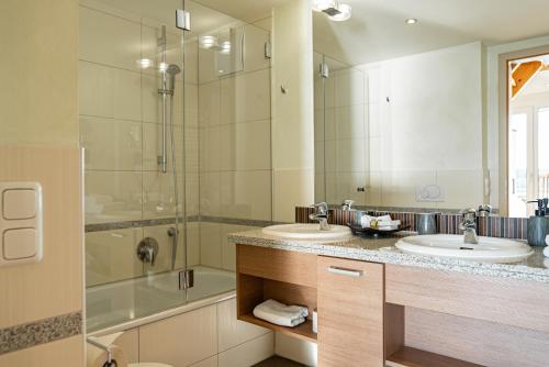 a bathroom with two sinks and a shower at Hotel Seeblick in Thülsfeld