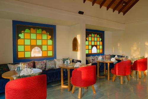 a restaurant with tables and red chairs and a couch at OBLU NATURE Helengeli-All-Inclusive with free Transfers in North Male Atoll