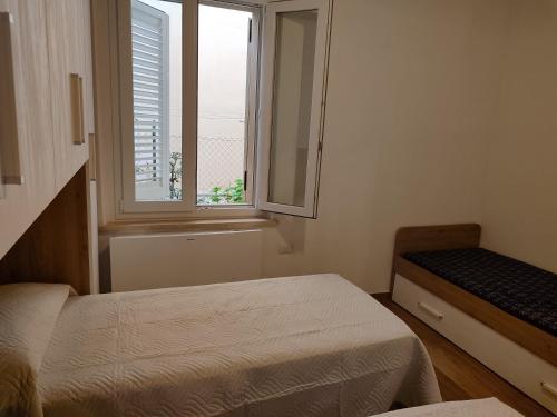 a small bedroom with two beds and a window at VILLETTA INDIPENDENTE in Alba Adriatica