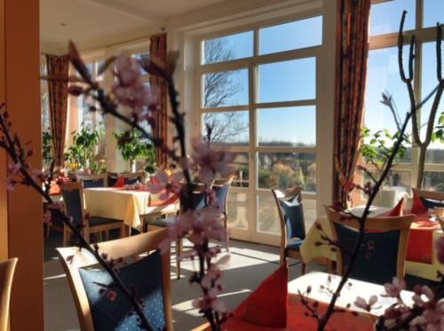 a dining room with tables and chairs and a large window at Hotel & Restaurant Zum Kap Arkona in Putgarten