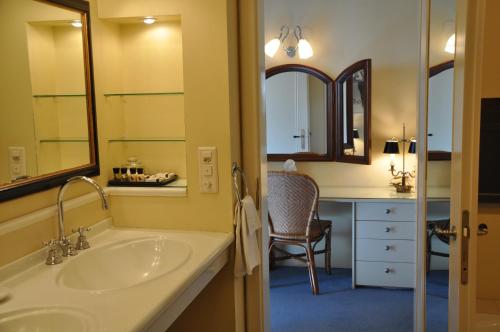 a bathroom with a sink and a desk with a chair at Unique Hotel Innere Enge in Bern