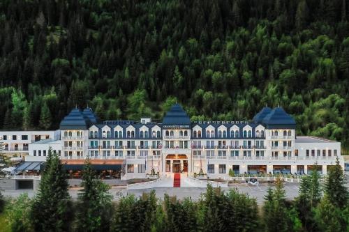 a large white building with a red door at Grand Hotel Belushi in Boge