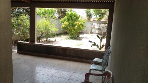 an open door to a patio with two chairs and a window at Lazer à beira mar in Alcobaça