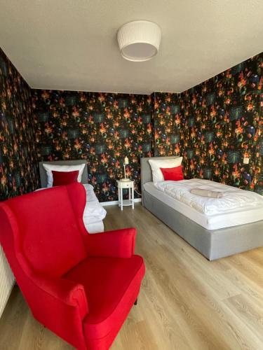 ein Schlafzimmer mit einem Bett und einem roten Stuhl in der Unterkunft Das Haus zur Rothen Thür 2 in Arnstadt