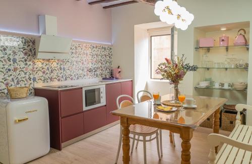 a kitchen with a table and a refrigerator and a table and chairs at Casa Rural La Molinera Etxea in Samaniego