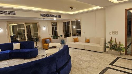 a large living room with blue couches and chairs at Royal Elegance Room in Sheikh Zayed