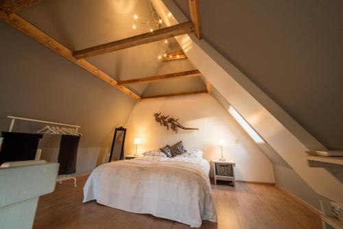 sypialnia z białym łóżkiem na poddaszu w obiekcie Torenhuis Medemblik w mieście Medemblik