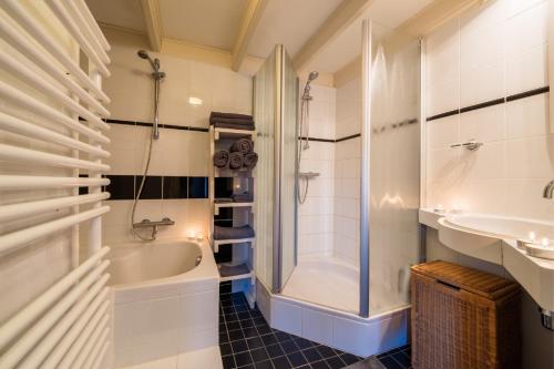 a bathroom with a tub and a shower and a sink at Torenhuis Medemblik in Medemblik