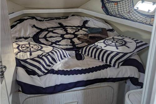 ein Bett mit schwarzer und weißer Decke auf einem Boot in der Unterkunft Yellow - Escapade à Hendaye in Hendaye
