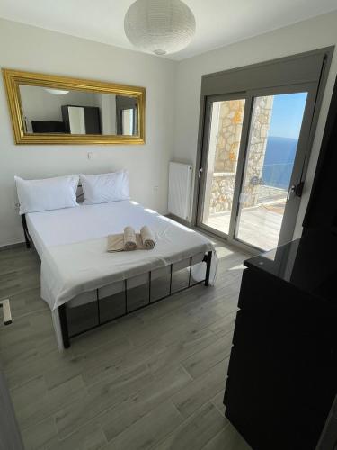 a bedroom with a large bed with a mirror at Villa Buddha in Syvota