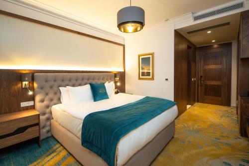 a hotel room with a bed and a television at Grand Hotel Belushi in Boge