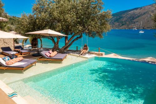 a swimming pool next to a body of water at Plataria Seaside Resort in Plataria