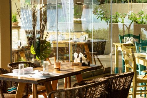 a restaurant with tables and chairs and a window at Plataria Seaside Resort in Plataria