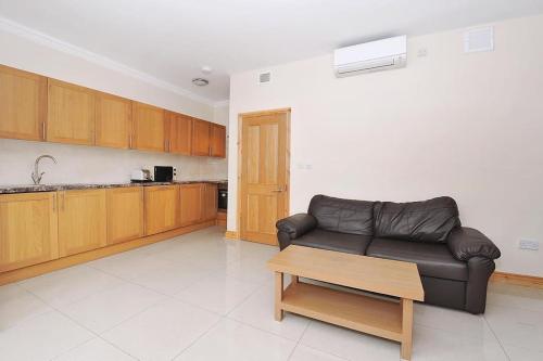 a living room with a leather couch and a table at 1 bedroom apartment in Leicester Square in London