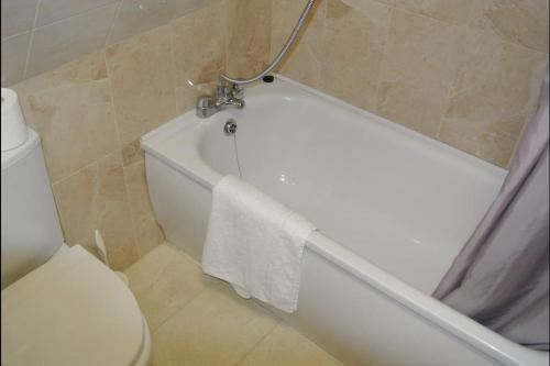 1 bedroom apartment in Leicester Square في لندن: حمام مع حوض استحمام أبيض ومرحاض