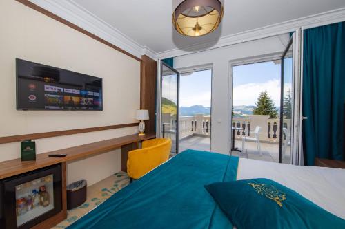 a hotel room with a bed and a large window at Grand Hotel Belushi in Boge
