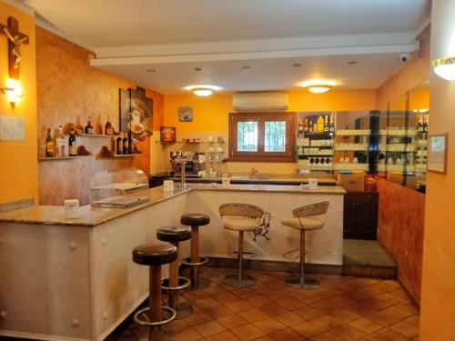 eine Küche mit gelben Wänden und einer Theke mit Hockern in der Unterkunft ALBERGO AL GALLO in Sanguinetto