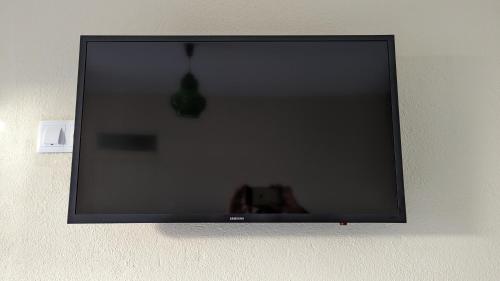 a flat screen tv hanging on a wall at Banana Tree House in Ponta do Sol