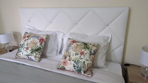 a white bed with two pillows on it at Banana Tree House in Ponta do Sol