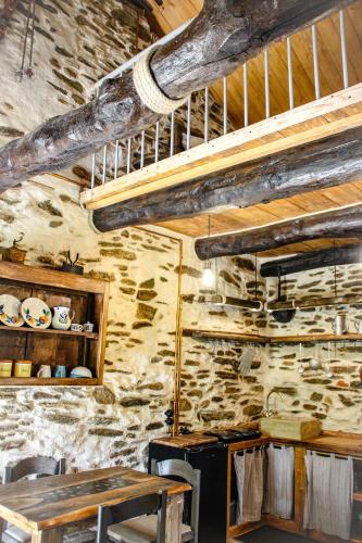 a kitchen with a table and a stone wall at il Bosco in Roccaforte Mondovì