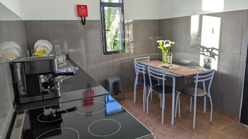 a kitchen with a table with chairs and a coffee maker at Banana Tree House in Ponta do Sol