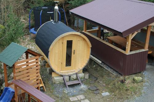 a small wooden play structure with a small house at Chata na Orave so saunou a kúpacou kaďou in Námestovo