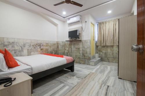 een slaapkamer met een bed en een tv aan de muur bij Hotel Holiday Rani Gunj Opp Punjab national bank in Secunderābād