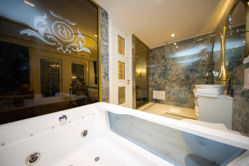 a large bathroom with a tub and a toilet at Grand Hotel Belushi in Boge