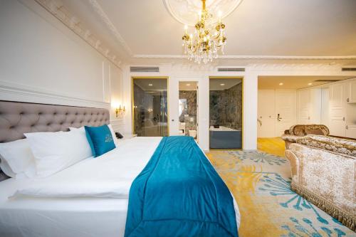 a bedroom with a large white bed and a chandelier at Grand Hotel Belushi in Boge
