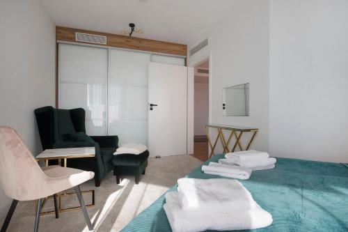 ein Wohnzimmer mit einem grünen Sofa und Stühlen in der Unterkunft Apartament Premium PINEA 302 in Pobierowo