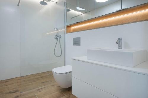 a white bathroom with a sink and a toilet at Apartament Premium PINEA 302 in Pobierowo