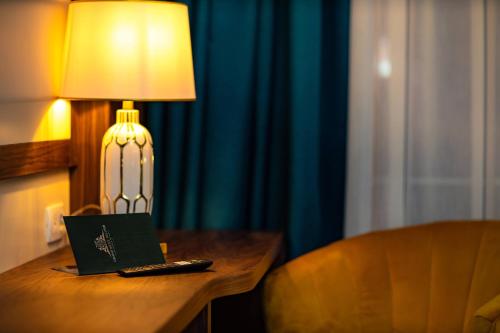 a laptop sitting on a table next to a lamp at Grand Hotel Belushi in Boge