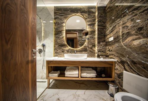 a bathroom with a sink and a mirror at Grand Hotel Belushi in Boge
